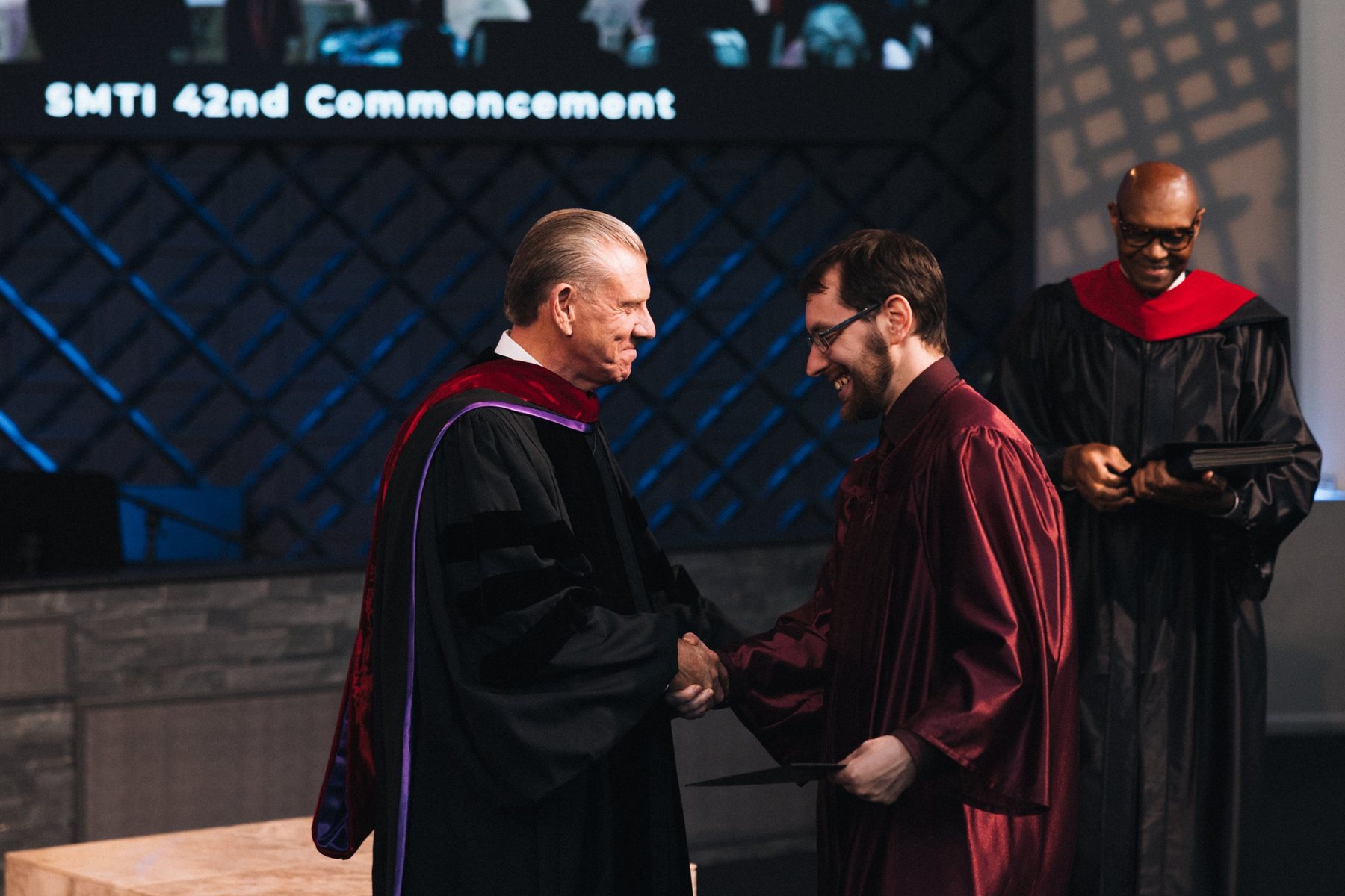 A graduate receiving a diploma